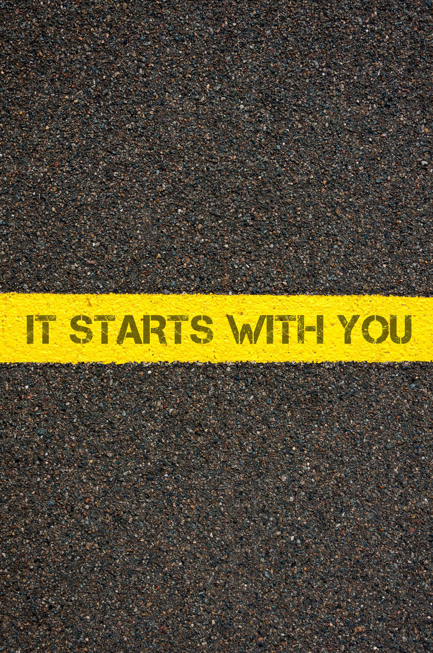 CLOSE-UP OF YELLOW SIGN ON ROAD