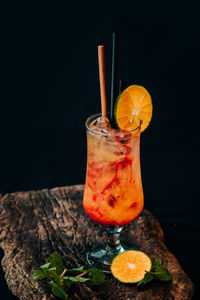 Close-up of orange juice in glass against black background