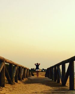 Woman standing on walkway on the beach