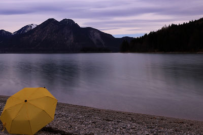 Scenic view of lake by mountains against sky