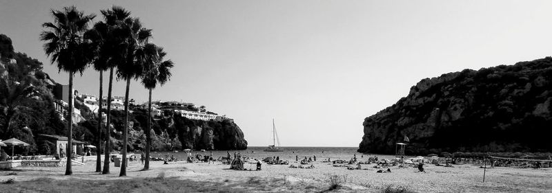 Panoramic view of people on beach against clear sky