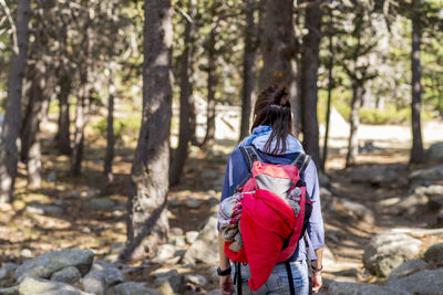 Rear view of woman with backpack in forest