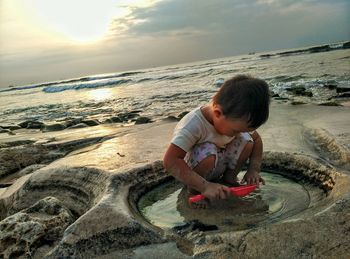 Boy on beach against sky