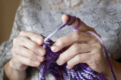 Midsection of woman knitting wool