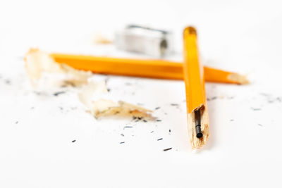 High angle view of broken pencils on white background