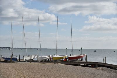 Boats moored on beach against sky