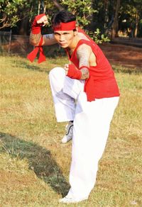 Side view of woman with umbrella standing on field