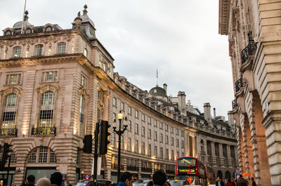 People on street amidst buildings in city