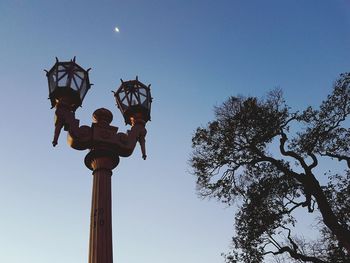 Low angle view of illuminated street light against clear sky