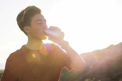 Full length of young man standing against sky on sunny day