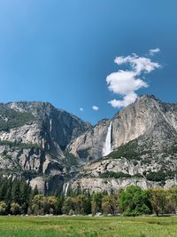 Scenic view of landscape and mountains against blue sky