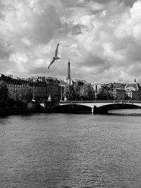 Bridge over river in city against sky