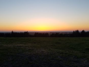 Scenic view of field against clear sky during sunset