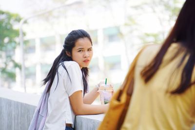 Portrait of young woman with drink outdoors