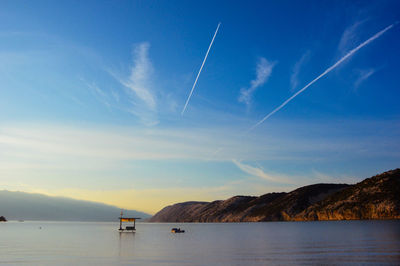 Scenic view of calm sea against mountain range