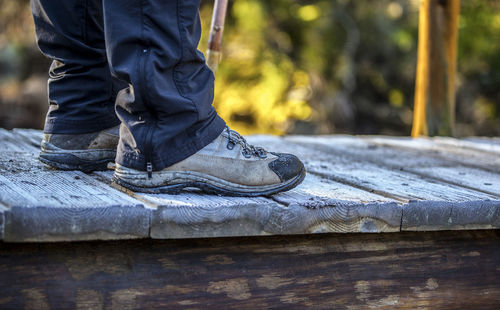 Hiker crossing a frozen wooden bridge