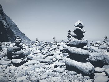 Pebbles on shore against clear sky