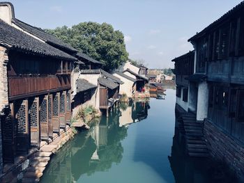 Canal amidst buildings in town against sky