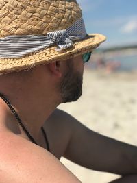 Close-up of shirtless man wearing hat at beach