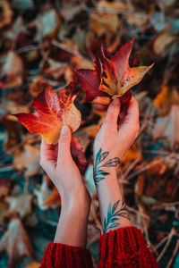 Close-up of woman with autumn leaves