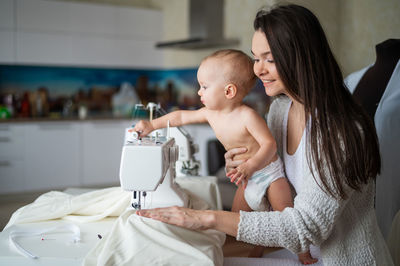 Mother and son sitting by sewing machine