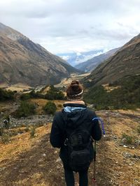 Rear view of man looking at mountain against sky