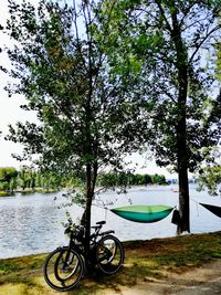 Bicycle by lake against sky