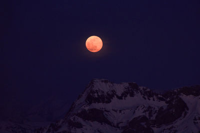 Scenic view of snowcapped mountains against sky at night