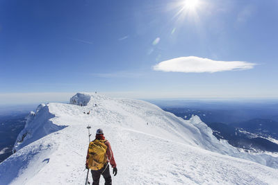 A man climbs to the summit of mt. hood in oregon.