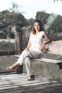 Portrait of woman sitting on wood