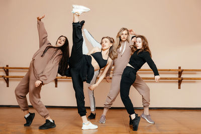 Group of girls in sportswear, performing elements of house dance in a dance studio, dancing with