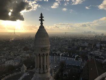 Aerial view of buildings in city at sunset