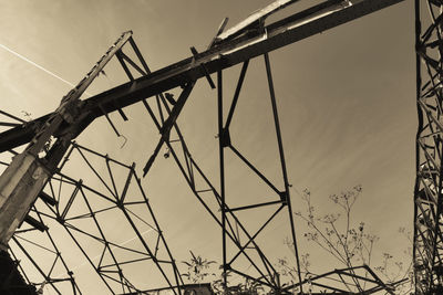 Low angle view of silhouette cranes against sky