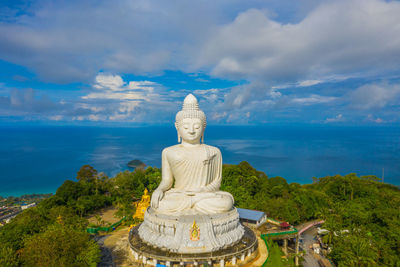 Rear view of woman standing by sea against sky