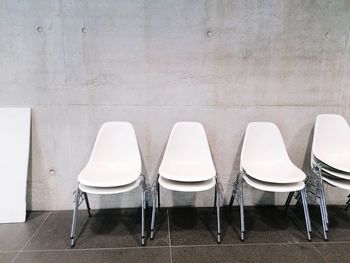 Close-up of empty chairs against wall