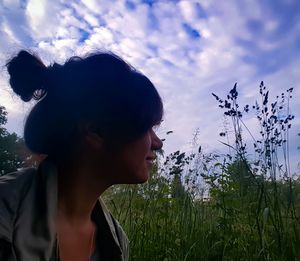 Woman looking away against sky