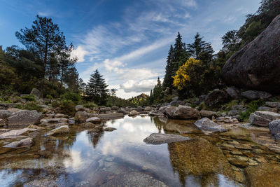 Scenic view of waterfall against sky
