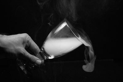 Midsection of man holding cigarette in the dark