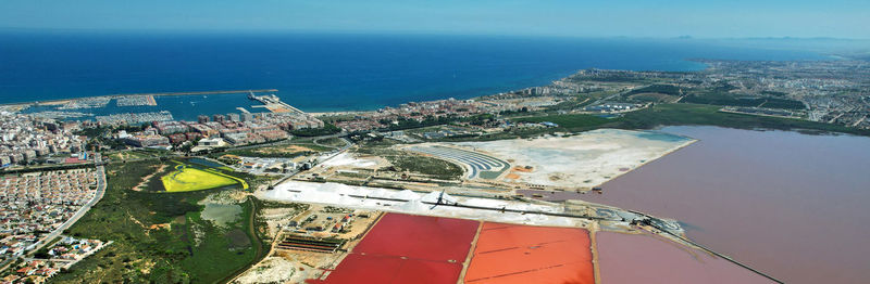 High angle view of buildings by sea against sky