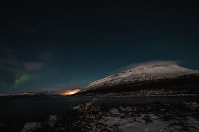 Scenic view of snowcapped mountains against sky at night