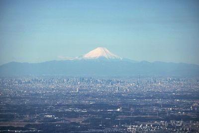 Scenic view of cityscape and mountains against sky