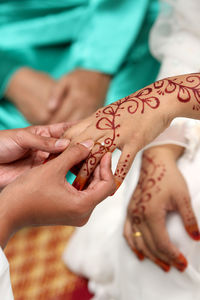 Cropped image of bridegroom wearing wedding ring to bride