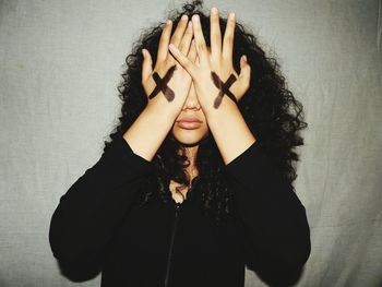 Young woman covering eyes with hands