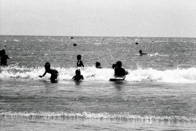 Men in sea against sky