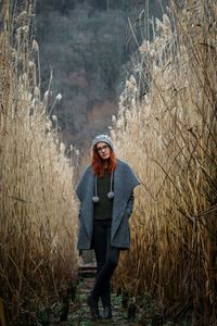 Portrait of young woman standing on field