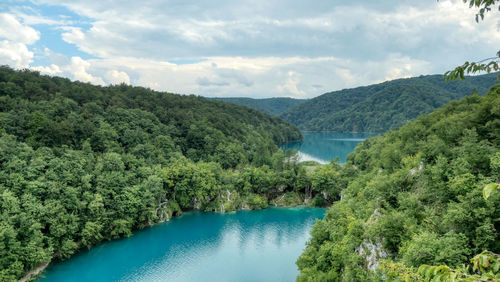 Scenic view of plitvice lakes amidst trees against sky