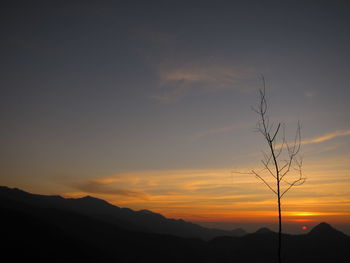 Scenic view of silhouette mountains against orange sky