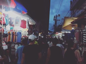 Crowd in market against sky in city