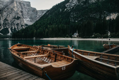 Boats moored on lake against mountains