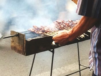 Man preparing food on barbecue grill